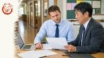 Foreign teacher and Japanese school administrator reviewing onboarding documents for a child-facing education job in Japan